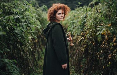 Portrait of woman standing by plants