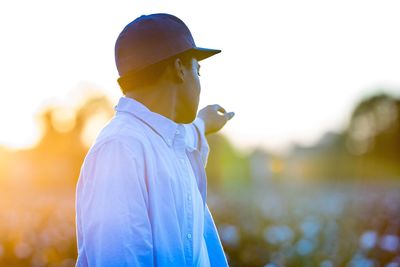 Close-up of man gesturing against sky