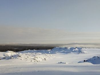Snow covered landscape against sky