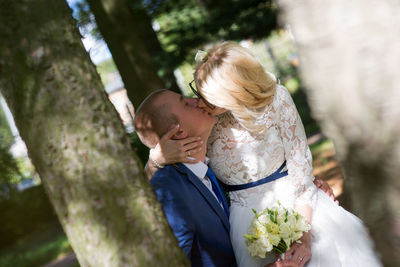 Bridal couple kissing at park