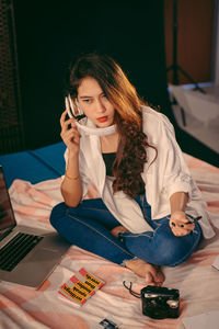 Young woman using mobile phone at home