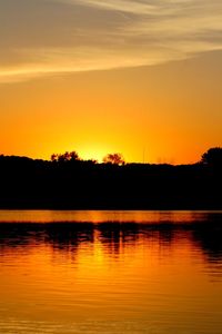 Scenic view of lake against orange sky
