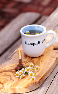 Close-up of white daisies in herbal tea on table