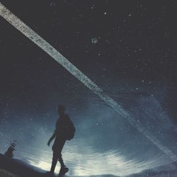 Full length of man standing on road against sky at night