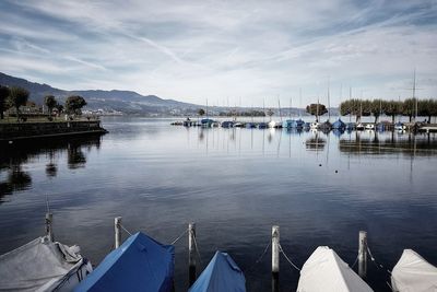 Boats moored in lake against sky