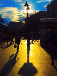 Woman standing on city street at sunset