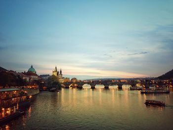 Bridge over river against buildings in city