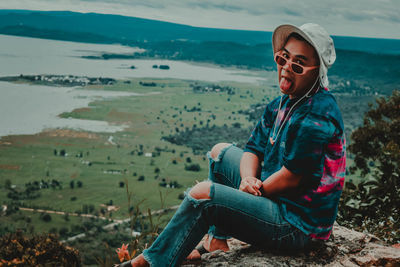 Full length of young man sitting on land