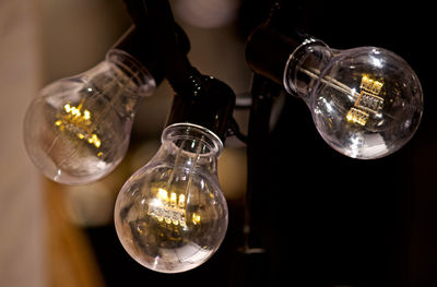 Close-up of illuminated light bulb on table