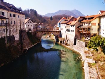 Bridge over river amidst buildings against sky