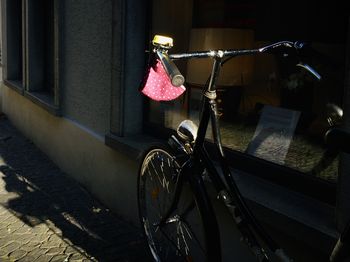 Bicycle hanging on railing by street in city