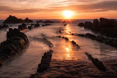 Scenic view of rocks against sky during sunset