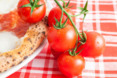 Close-up of tomatoes and pizza on table at home