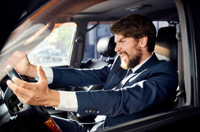 Young man sitting in car