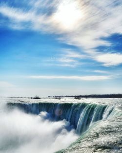 Scenic view of waterfall against sky