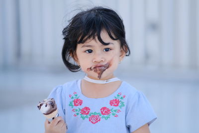 Portrait of cute girl eating ice cream outdoors