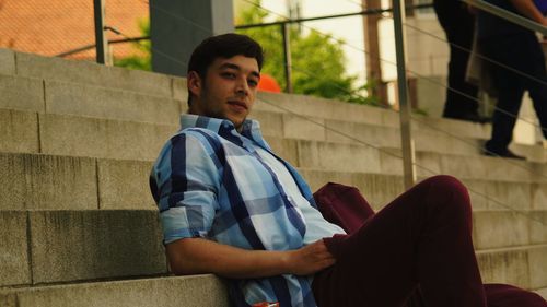 Low angle portrait of man sitting on steps