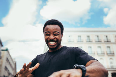 Portrait of smiling man standing against city