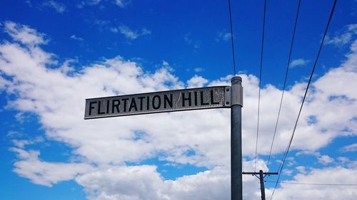 Low angle view of road sign against sky