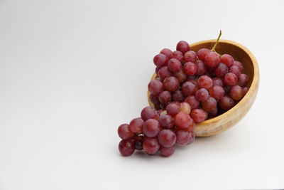 Close-up of grapes in bowl against white background