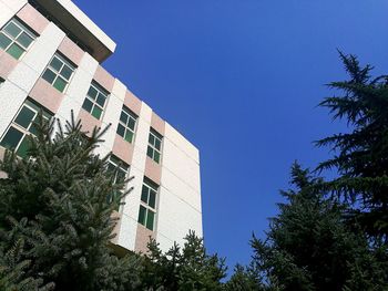 Low angle view of apartment building against clear blue sky