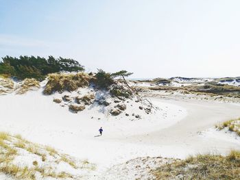 People on beach against clear sky