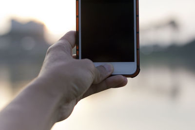 Cropped hand holding mobile phone