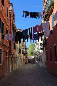 Alley amidst buildings in city against sky