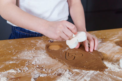 A little girl makes heart-shaped cookies from rye dough. the concept of valentine's day