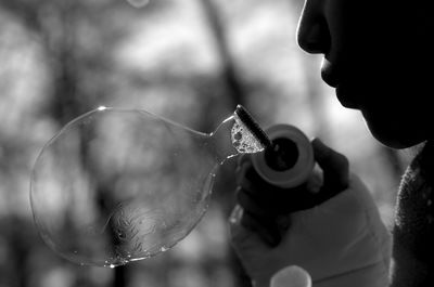 Cropped woman blowing bubble