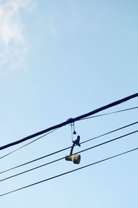 Low angle view of power lines against clear blue sky