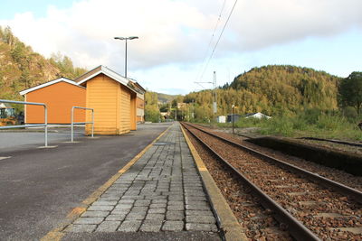 Railroad tracks amidst buildings against sky