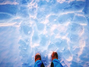 Low section of person standing on snow