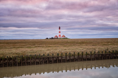 Lighthouse by sea against sky