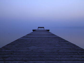 Wooden pier on sea against sky during sunset