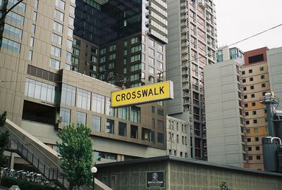 Low angle view on text on signboard against modern building