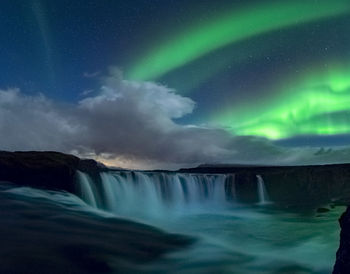 Scenic view of waterfall against sky at night