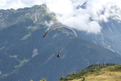 Person paragliding over mountain