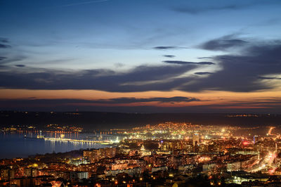 High angle view of illuminated city against sky at sunset