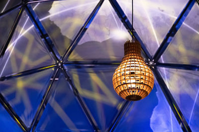 Low angle view of illuminated light bulbs hanging from ceiling