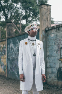 Portrait of young man standing against built structure