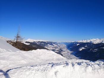 Scenic view of snowcapped mountains against clear blue sky