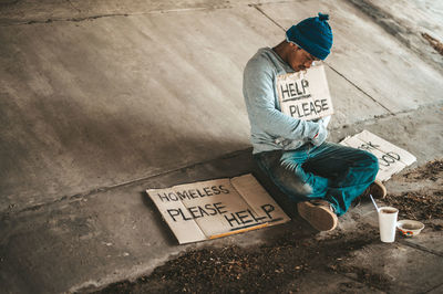 High angle view of man sitting on street