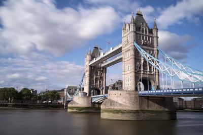 Low angle view of tower bridge against cloudy sky