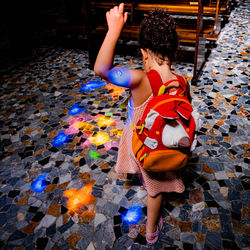Rear view of child playing with lights