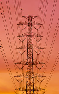 Low angle view of silhouette electricity pylon against sky during sunset