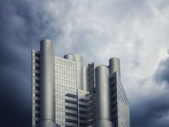 Low angle view of modern building against cloudy sky