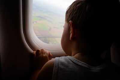 Portrait of boy looking through airplane window