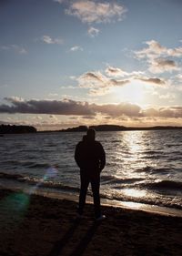 Rear view of man looking at sea against sky