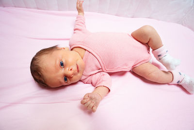 Portrait of cute baby boy lying on bed at home